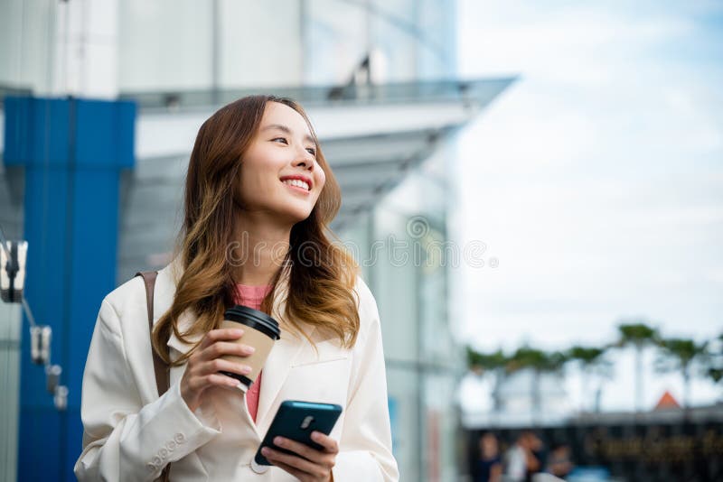 ασιάτισσα επιχειρηματίας με smartphone και καφέ μπροστά στο κτίριο του δρόμου κοντά στο γραφείο στοκ φωτογραφία με δικαίωμα ελεύθερης χρήσης