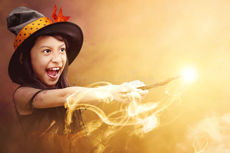ασιάτισσα μάγισσα κοριτσάκι που χρησιμοποιεί το ραβδί με μια μαγική λάμψη με μυστικιστική φωτιά
