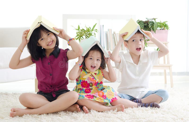 Asian kids putting books on their head. Asian kids putting books on their head