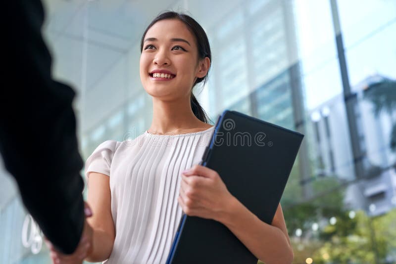 Beautiful asian chinese business woman shaking hands in modern city work office. Beautiful asian chinese business woman shaking hands in modern city work office