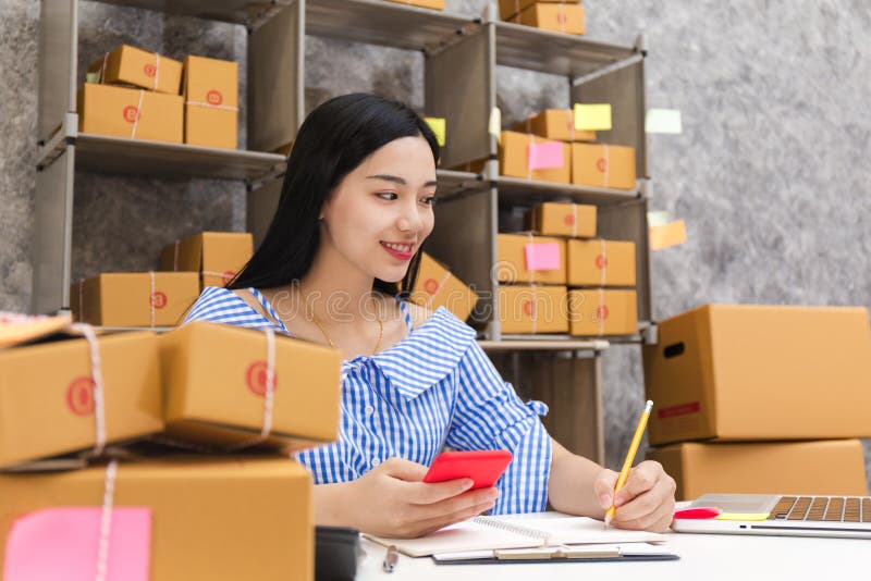 Asian woman with product packaging work at home concept, small and medium-sized enterprises SMEs concept. Asian woman with product packaging work at home concept, small and medium-sized enterprises SMEs concept.
