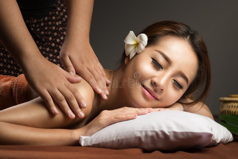 Asian woman having massage and spa salon Beauty treatment concept. Masseur doing massage on female shoulder in the beauty salon. Asian woman having massage and spa salon Beauty treatment concept. Masseur doing massage on female shoulder in the beauty salon.