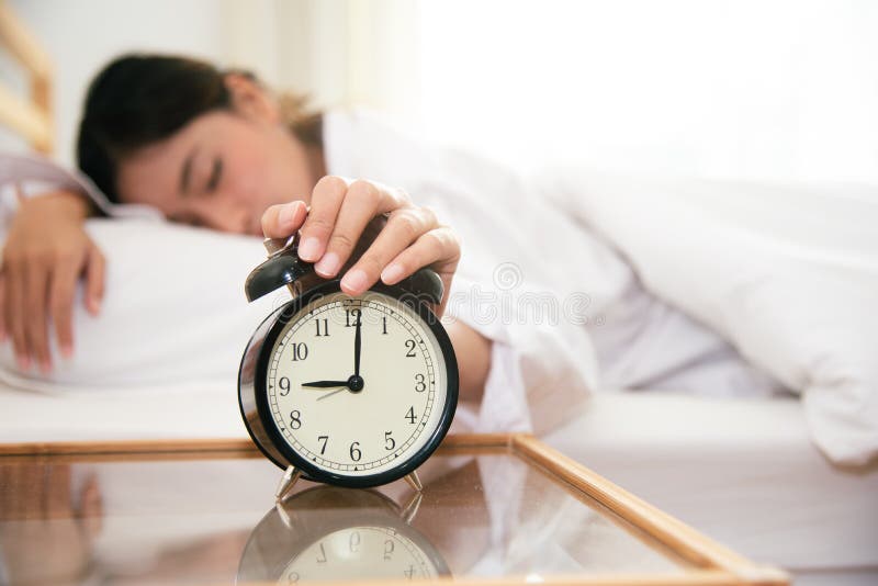 Asian young beauty woman turning off alarm clock in morning late without looking clock and lazy to working on in holiday. Bedroom and bed time concept. Relaxation and people lifestyles of tired worker, afternoon, silent, waking, up, getting, early, female, home, rest, pillow, nap, sleep, sleepy, girl, stress, bedding, routine, hand, healthy, bedtime, resting, person, adult, lying, serene, background, asleep, closeup, night. Asian young beauty woman turning off alarm clock in morning late without looking clock and lazy to working on in holiday. Bedroom and bed time concept. Relaxation and people lifestyles of tired worker, afternoon, silent, waking, up, getting, early, female, home, rest, pillow, nap, sleep, sleepy, girl, stress, bedding, routine, hand, healthy, bedtime, resting, person, adult, lying, serene, background, asleep, closeup, night