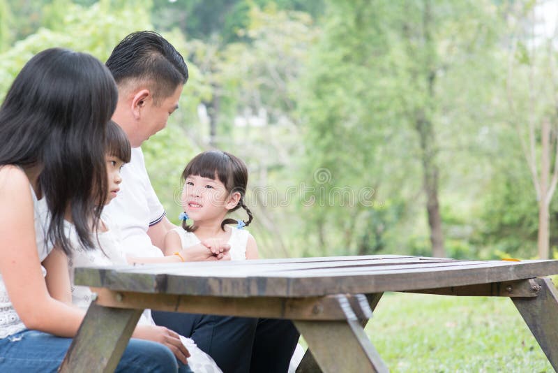 Ασιατική οικογένεια με το κενό επιτραπέζιο διάστημα
