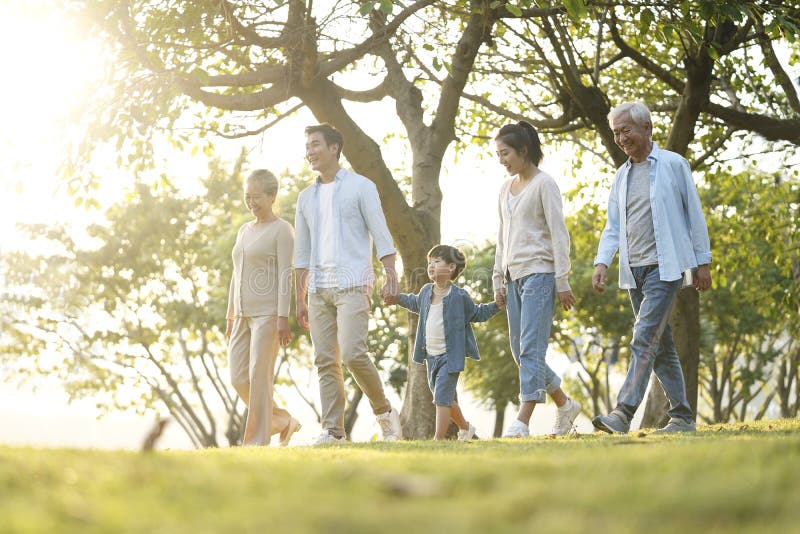 Three generation happy asian family walking outdoors in park. Three generation happy asian family walking outdoors in park