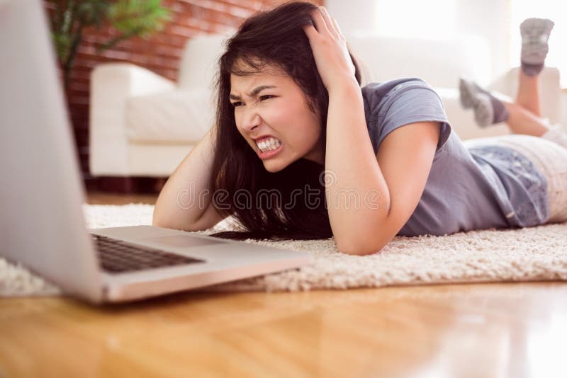 Ασιατικήη γυναίκα που χρησιμοποιεί το lap-top στο πάτωμα στοκ φωτογραφίες Ασιατικήη γυναίκα που χρησιμοποιεί το lap-top στο πάτωμα στοκ φωτογραφίες