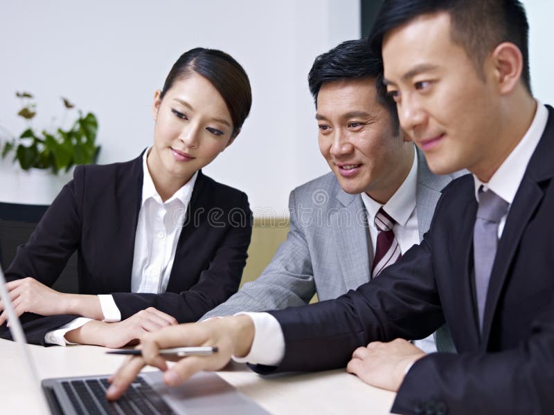 A team of asian business people working together in office. A team of asian business people working together in office.