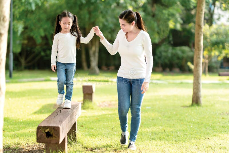 Ασιατικό mom και χαριτωμένο παιχνίδι χεριών εκμετάλλευσης παιδιών μωρών μαζί στον ξύλινο περίπατο κούτσουρων στην υπαίθρια παιδικ στοκ φωτογραφία με δικαίωμα ελεύθερης χρήσης Ασιατικό mom και χαριτωμένο παιχνίδι χεριών εκμετάλλευσης παιδιών μωρών μαζί στον ξύλινο περίπατο κούτσουρων στην υπαίθρια παιδικ στοκ φωτογραφία με δικαίωμα ελεύθερης χρήσης
