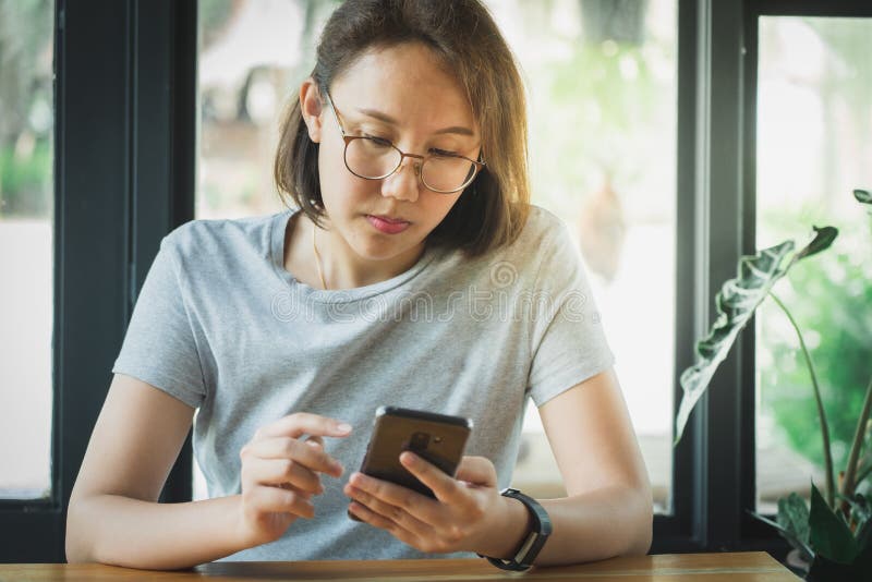 Ασιατικό smartphone παιχνιδιού κοριτσιών για την ψυχαγωγία και εργασία έξω από το γραφείο ή το εξωτερικό Από την εργασία εννοιών στοκ εικόνες Ασιατικό smartphone παιχνιδιού κοριτσιών για την ψυχαγωγία και εργασία έξω από το γραφείο ή το εξωτερικό Από την εργασία εννοιών στοκ εικόνες