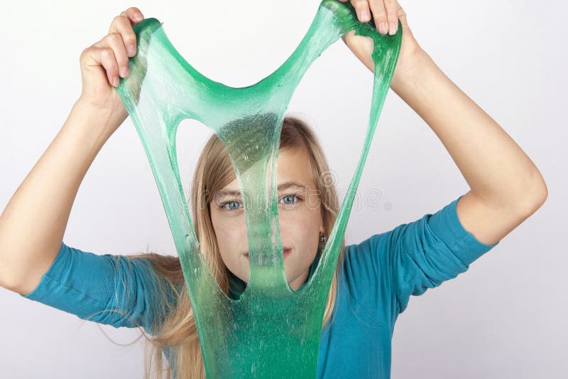 Αστείο κορίτσι που κρατά πράσινο slime μπροστά από το πρόσωπό της στοκ φωτογραφία Αστείο κορίτσι που κρατά πράσινο slime μπροστά από το πρόσωπό της στοκ φωτογραφία
