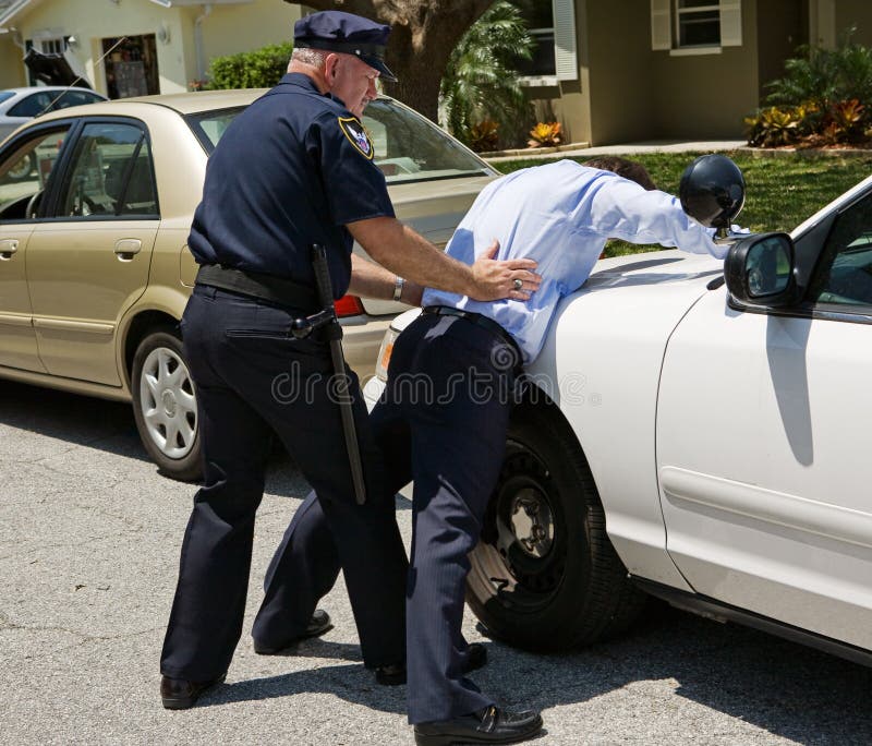 Drunk driver spread eagle on the police car, being patted down. Drunk driver spread eagle on the police car, being patted down.