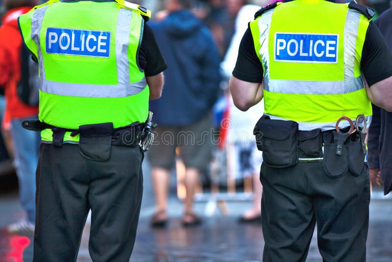 Police officers with bright yellow vests on duty. Police officers with bright yellow vests on duty