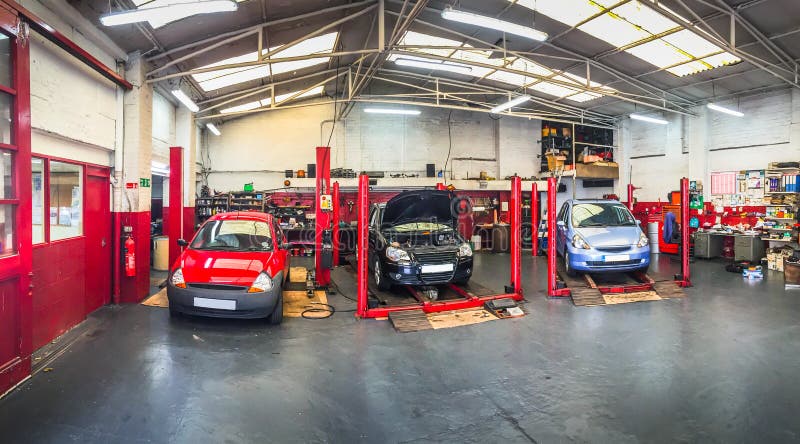 Automotive auto car repair shop service bays garage with vehicles on ramps. Automotive auto car repair shop service bays garage with vehicles on ramps.