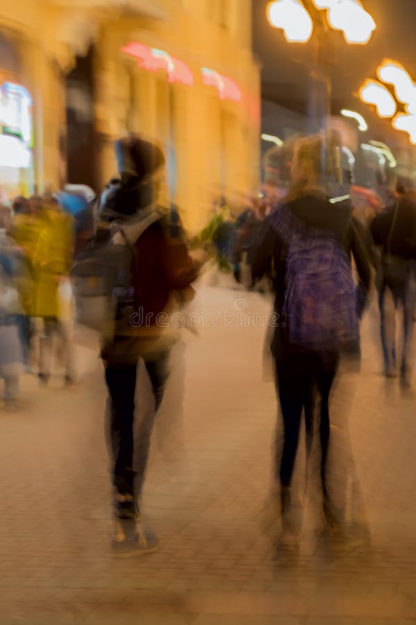 Αφηρημένη εκλεκτής ποιότητας κίνηση τόνου Εικόνα θαμπάδων της οδού, του κοριτσιού και του τύπου με σακίδια πλάτης, φωτεινά φω'τα στοκ εικόνα Αφηρημένη εκλεκτής ποιότητας κίνηση τόνου Εικόνα θαμπάδων της οδού, του κοριτσιού και του τύπου με σακίδια πλάτης, φωτεινά φω'τα στοκ εικόνα