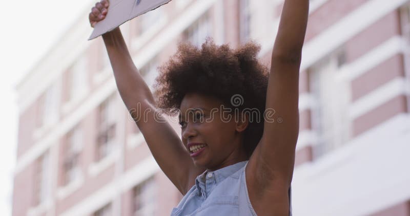 αφρικανή γυναίκα κρατώντας ένα πλακάτ φωνάζοντας κατά τη διάρκεια διαμαρτυρίας