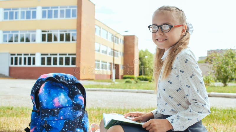 Porter of an 11 year old schoolgirl girl sitting on the background of her school. Porter of an 11 year old schoolgirl girl sitting on the background of her school