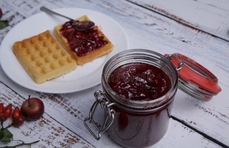 βάζο μαρμελάδα φράουλα και ένα πιάτο βελγικές βάφλες σε λευκό τραπέζι στοκ φωτογραφίες με δικαίωμα ελεύθερης χρήσης