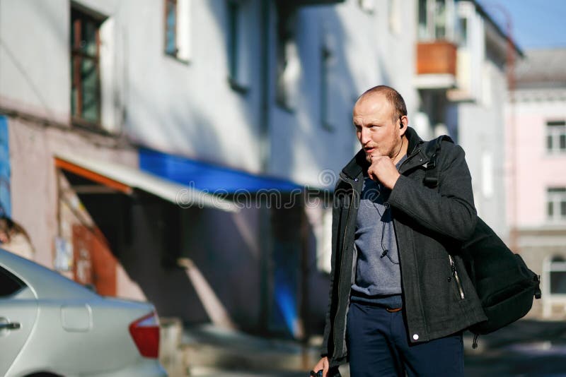 Βάναυσος φωτογράφος οδών με τις διαθέσιμες strolling οδούς πόλεων καμερών, που μιλούν walkie-talkie με ελεύθερα χέρια στοκ φωτογραφία Βάναυσος φωτογράφος οδών με τις διαθέσιμες strolling οδούς πόλεων καμερών, που μιλούν walkie-talkie με ελεύθερα χέρια στοκ φωτογραφία