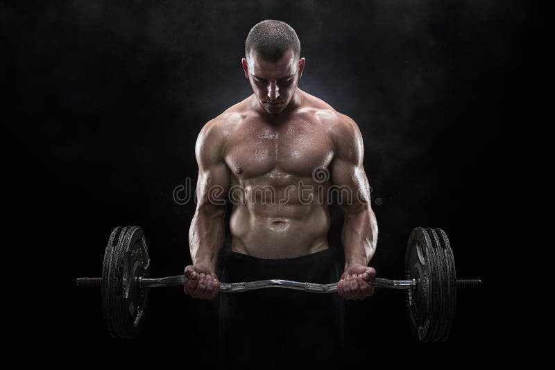 Close up of young muscular man lifting weights over dark background. Close up of young muscular man lifting weights over dark background