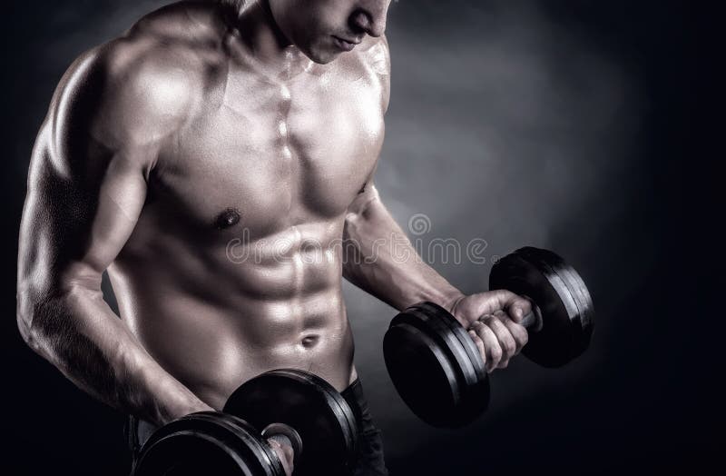 Closeup of a muscular young man lifting weights on dark background. Closeup of a muscular young man lifting weights on dark background