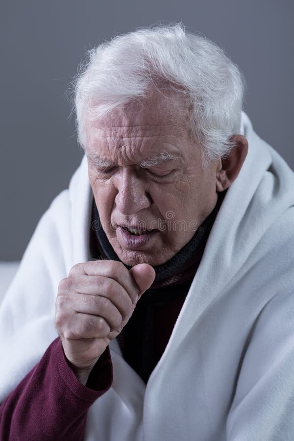 Ill coughing senior man covered with blanket. Ill coughing senior man covered with blanket