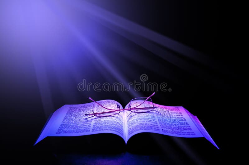 Open Bible with reading glasses beamed with rays of light. Open Bible with reading glasses beamed with rays of light.