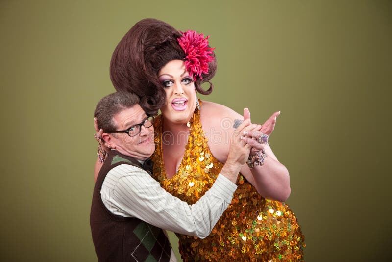 Drag queen and Caucasian nerd on green background hold hands. Drag queen and Caucasian nerd on green background hold hands