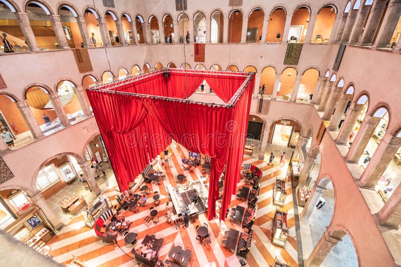 VENICE, ITALY - AUGUST 02, 2021: Huge indoor hall of Fondaco dei Tedeschi. Former headquarters and restricted living quarters of the German merchants. Today luxurious department store and cafe. Venice, Italy. VENICE, ITALY - AUGUST 02, 2021: Huge indoor hall of Fondaco dei Tedeschi. Former headquarters and restricted living quarters of the German merchants. Today luxurious department store and cafe. Venice, Italy.