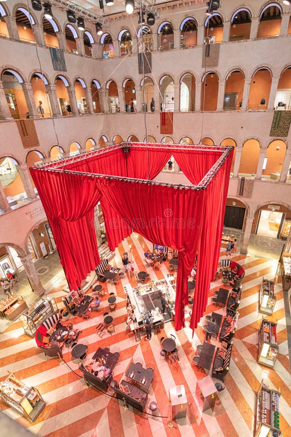 VENICE, ITALY - AUGUST 02, 2021: Huge indoor hall of Fondaco dei Tedeschi. Former headquarters and restricted living quarters of the German merchants. Today luxurious department store and cafe. Venice, Italy. VENICE, ITALY - AUGUST 02, 2021: Huge indoor hall of Fondaco dei Tedeschi. Former headquarters and restricted living quarters of the German merchants. Today luxurious department store and cafe. Venice, Italy.