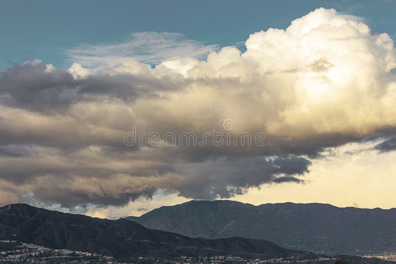 Βουνά με τα σπίτια cloudscape με το σωρείτη, σύννεφα Nimbus με το μπλε ουρανό στοκ φωτογραφία με δικαίωμα ελεύθερης χρήσης