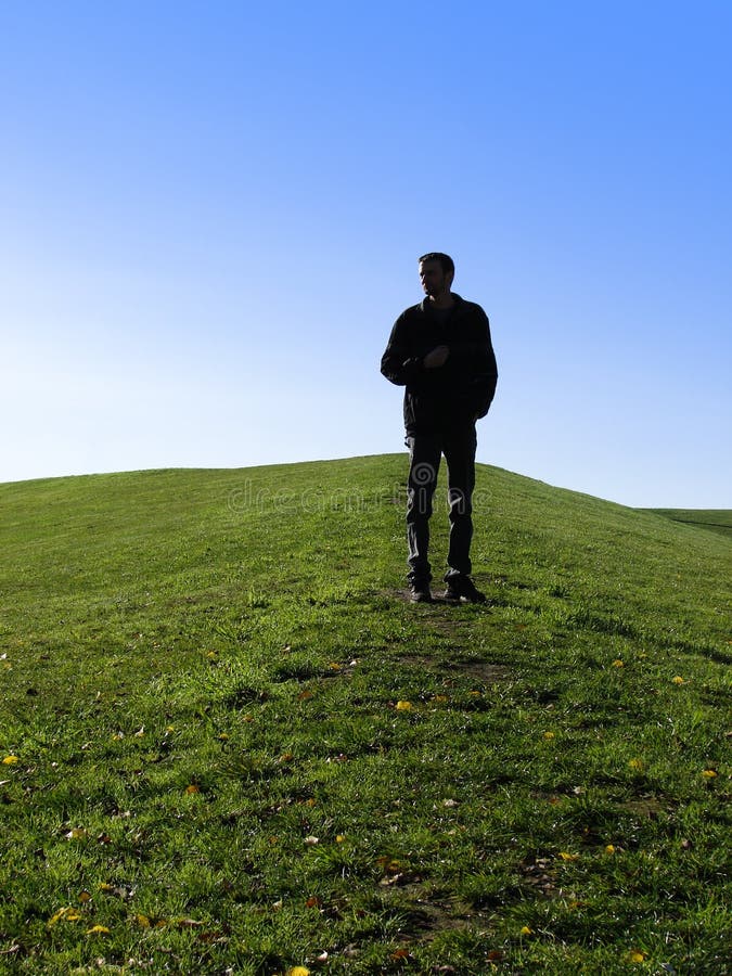 Sillouette of a man standing on a mountain on a clear day. Sillouette of a man standing on a mountain on a clear day