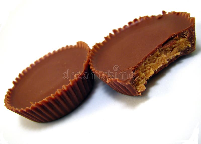 A pair of peanut butter cups with one bite missing. A pair of peanut butter cups with one bite missing