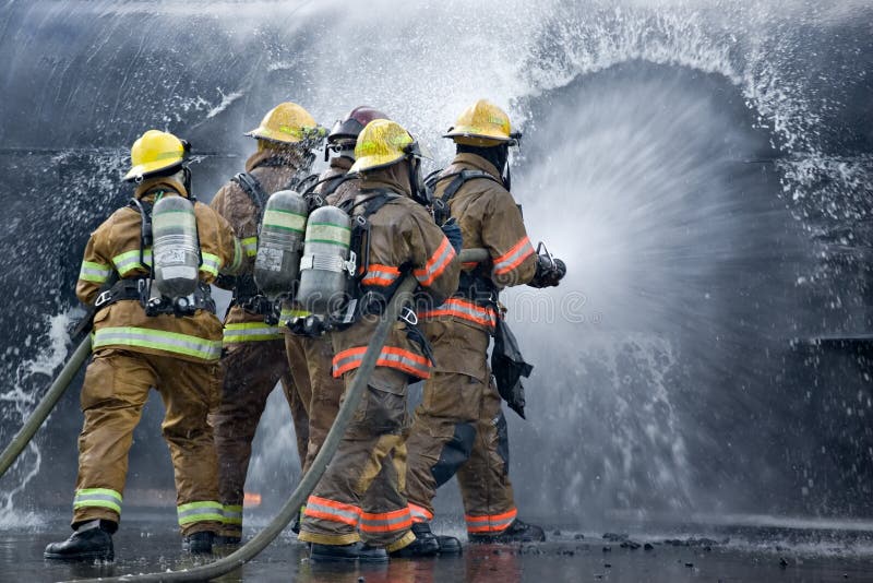 Group of drenched firemen extinguishing fuel tank fire. Group of drenched firemen extinguishing fuel tank fire