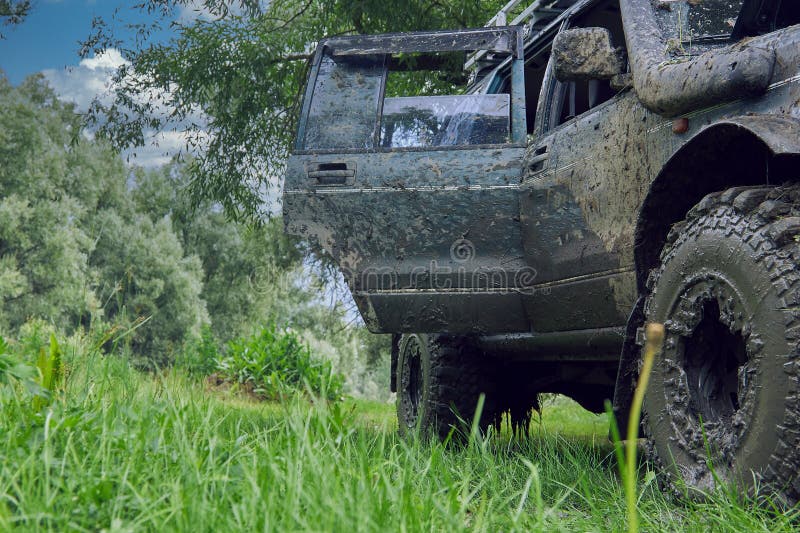 βρώμικο suv μετά από έναν ελεύθερο αγώνα στέκεται στη φύση με το καπό και την πόρτα ανοιχτή. βρώμικο 4x4 suv μετά από αγώνα εκτός δρόμου στέκεται στη φύση με ανοιχτή πόρτα σε μπλε φόντο ουρανού. αυτοκίνητο με τέσσερις τροχούς σε ταξίδι με μεγάλη περιπέτεια