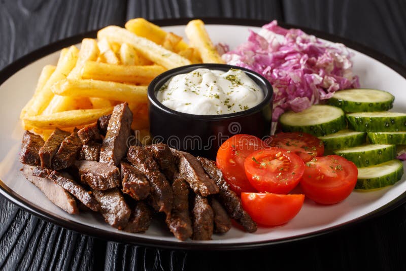 Βόειο κρέας Doner kebab σε ένα πιάτο με τις τηγανιτές πατάτες, την κινηματογράφηση σε πρώτο πλάνο σαλάτας και σάλτσας σε έναν πίν στοκ φωτογραφίες με δικαίωμα ελεύθερης χρήσης Βόειο κρέας Doner kebab σε ένα πιάτο με τις τηγανιτές πατάτες, την κινηματογράφηση σε πρώτο πλάνο σαλάτας και σάλτσας σε έναν πίν στοκ φωτογραφίες με δικαίωμα ελεύθερης χρήσης