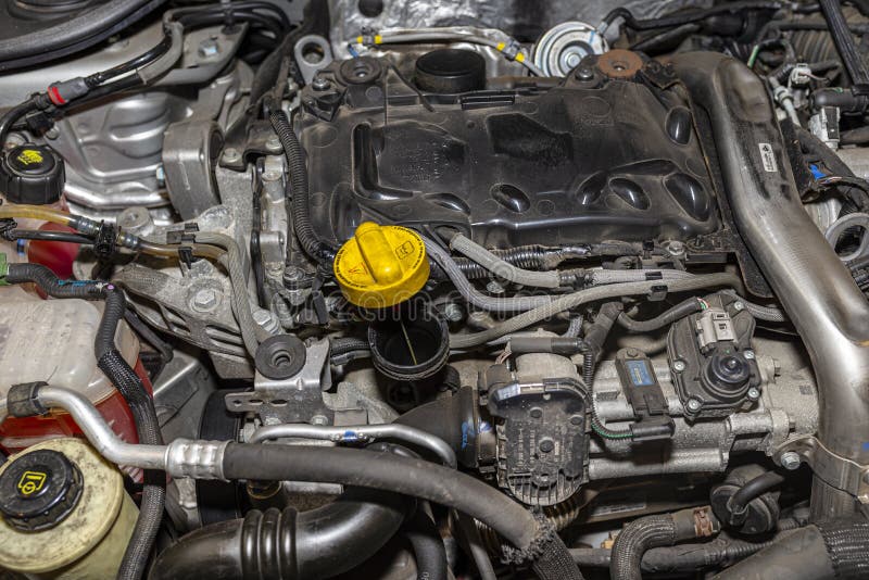 Bonn, Germany 3 March 2020. Engine compartment for Renault Laguna 3 Grandtour passenger car in station wagon body. Diesel engine with 150 horsepower, engine capacity 2.0 l. Visible engine components, fluids and electrical cables. Bonn, Germany 3 March 2020. Engine compartment for Renault Laguna 3 Grandtour passenger car in station wagon body. Diesel engine with 150 horsepower, engine capacity 2.0 l. Visible engine components, fluids and electrical cables.