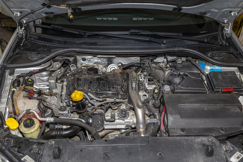 Bonn, Germany 3 March 2020. Engine compartment for Renault Laguna 3 Grandtour passenger car in station wagon body. Diesel engine with 150 horsepower, engine capacity 2.0 l. Visible engine components, fluids and electrical cables. Bonn, Germany 3 March 2020. Engine compartment for Renault Laguna 3 Grandtour passenger car in station wagon body. Diesel engine with 150 horsepower, engine capacity 2.0 l. Visible engine components, fluids and electrical cables.