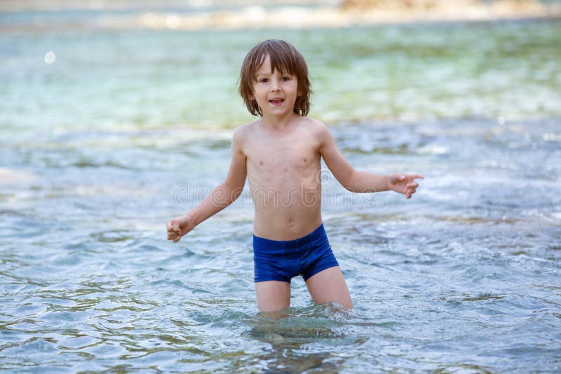 Sweet portrait of little boy on the beach, playing in the water, summertime. Sweet portrait of little boy on the beach, playing in the water, summertime