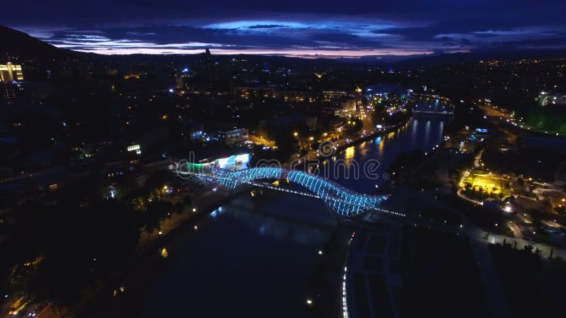 Γέφυρα της ειρήνης στο Tbilisi, που συλλαμβάνεται από την άποψη ματιών πουλιών, τη φωτεινότητα ακτίνων των οδηγήσεων