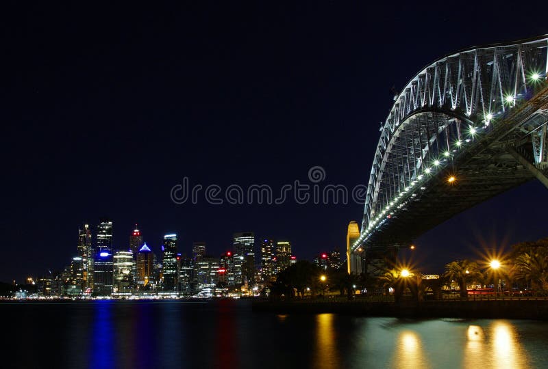 Night view of Sydney Harbour Bridge on lights and city skyline across the harbour. Night view of Sydney Harbour Bridge on lights and city skyline across the harbour