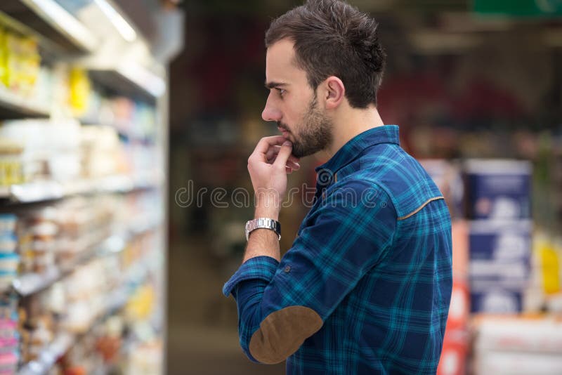 Γαλακτοκομικά προϊόντα αγοράς ατόμων χαμόγελου στην υπεραγορά στοκ εικόνα με δικαίωμα ελεύθερης χρήσης Γαλακτοκομικά προϊόντα αγοράς ατόμων χαμόγελου στην υπεραγορά στοκ εικόνα με δικαίωμα ελεύθερης χρήσης