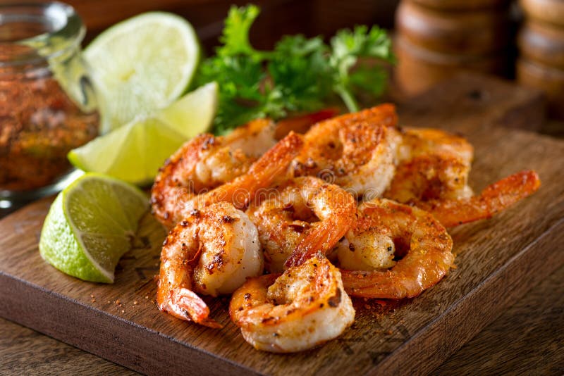 Delicious sauteed shrimp with cajun seasoning and lime on a maple plank. Delicious sauteed shrimp with cajun seasoning and lime on a maple plank.