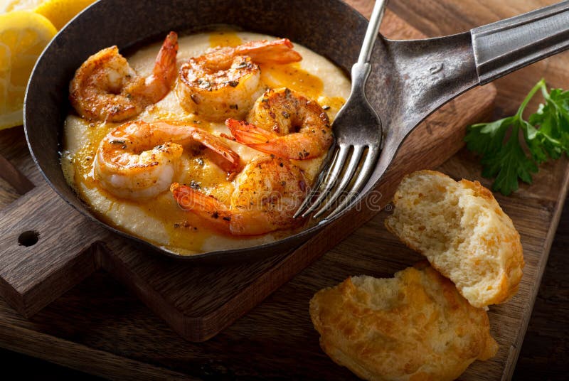 A pan of delicious fresh homemade cajun style shrimp and grits with cheddar biscuit. A pan of delicious fresh homemade cajun style shrimp and grits with cheddar biscuit.