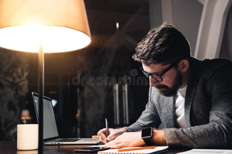 Γενειοφόρος συνάδελφος που εργάζεται από τον ξύλινο πίνακα με το lap-top Το δημιουργικό επιχειρησιακό άτομο κάνει το νέο γραφείο στοκ φωτογραφίες Γενειοφόρος συνάδελφος που εργάζεται από τον ξύλινο πίνακα με το lap-top Το δημιουργικό επιχειρησιακό άτομο κάνει το νέο γραφείο στοκ φωτογραφίες