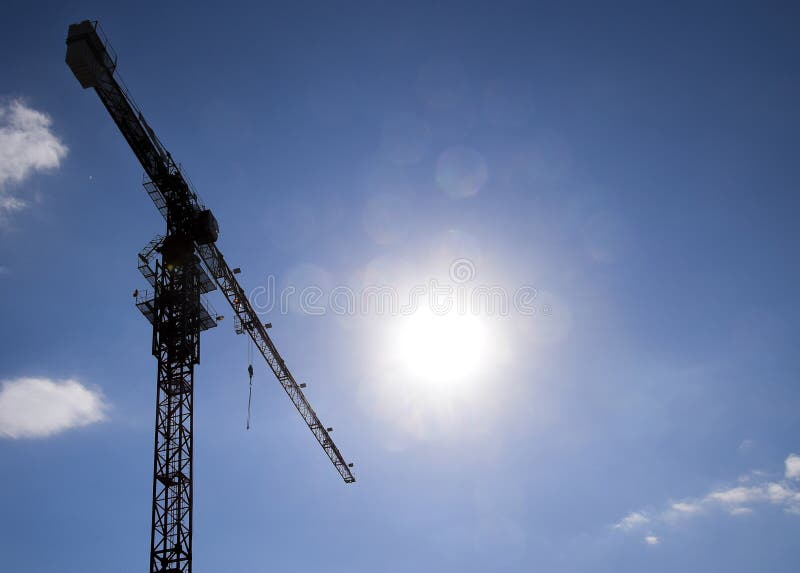 Γερανός οικοδόμησης πύργων ενάντια στο μπλε ουρανό και τον ήλιο σπίτι κατασκευής νέο Οικοδόμηση των νέων κτηρίων με έναν γερανό Π στοκ φωτογραφία με δικαίωμα ελεύθερης χρήσης Γερανός οικοδόμησης πύργων ενάντια στο μπλε ουρανό και τον ήλιο σπίτι κατασκευής νέο Οικοδόμηση των νέων κτηρίων με έναν γερανό Π στοκ φωτογραφία με δικαίωμα ελεύθερης χρήσης