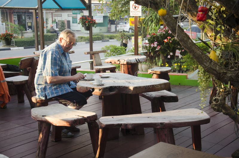 Γερμανικός ηληκιωμένος που τρώει το πρόγευμα στο χρόνο πρωινού στον ξύλινο πίνακα στοκ εικόνες Γερμανικός ηληκιωμένος που τρώει το πρόγευμα στο χρόνο πρωινού στον ξύλινο πίνακα στοκ εικόνες