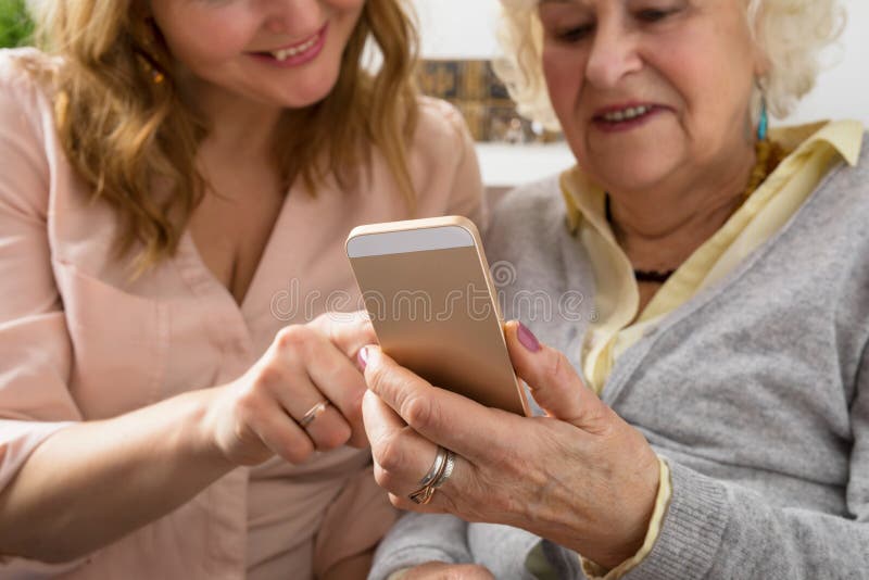 Γιαγιά και εγγονή που εξερευνούν το smartphone στοκ φωτογραφία Γιαγιά και εγγονή που εξερευνούν το smartphone στοκ φωτογραφία