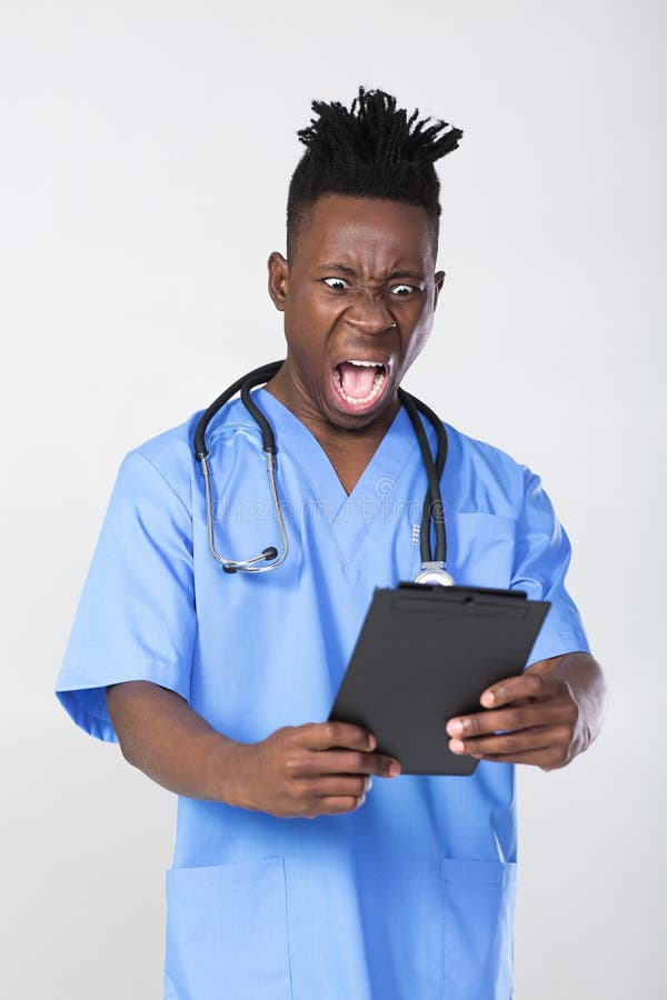 Surprised African-American male doctor screams on gray background. Surprised African-American male doctor screams on gray background