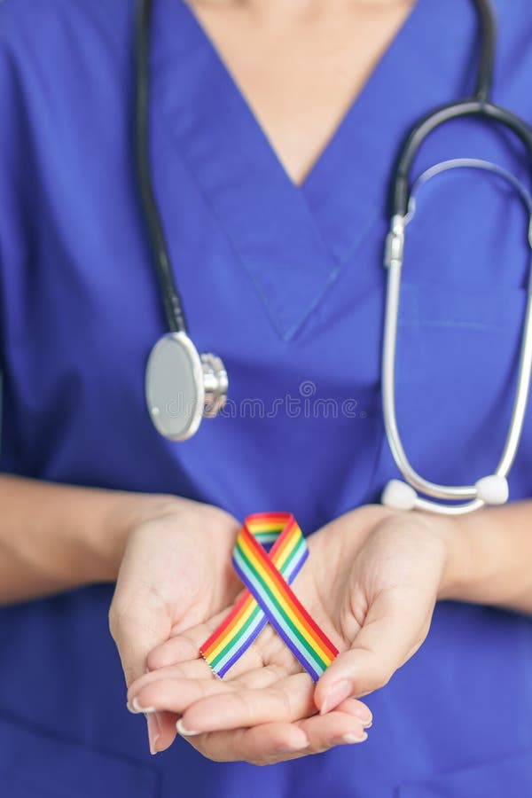 Γιατρός με κορδέλα ΛΟΑΤΚΙ Rainbow για την υποστήριξη της λεσβιακής κοινότητας ομοφυλόφιλων αμφιφυλόφιλων τρανσέξουαλ και κουήρ και στοκ εικόνα