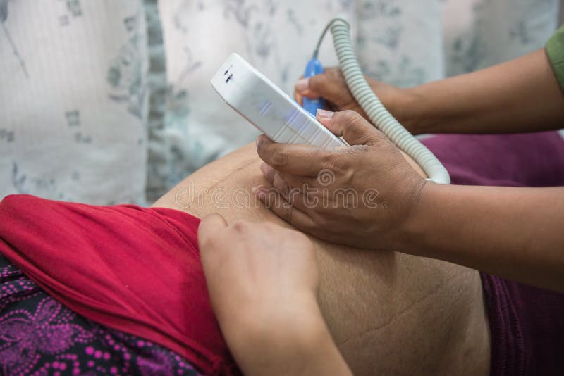 Γιατρός που ελέγχει επάνω τη νέα ασιατική κοιλιά γυναικών ` s στοκ εικόνες Γιατρός που ελέγχει επάνω τη νέα ασιατική κοιλιά γυναικών ` s στοκ εικόνες
